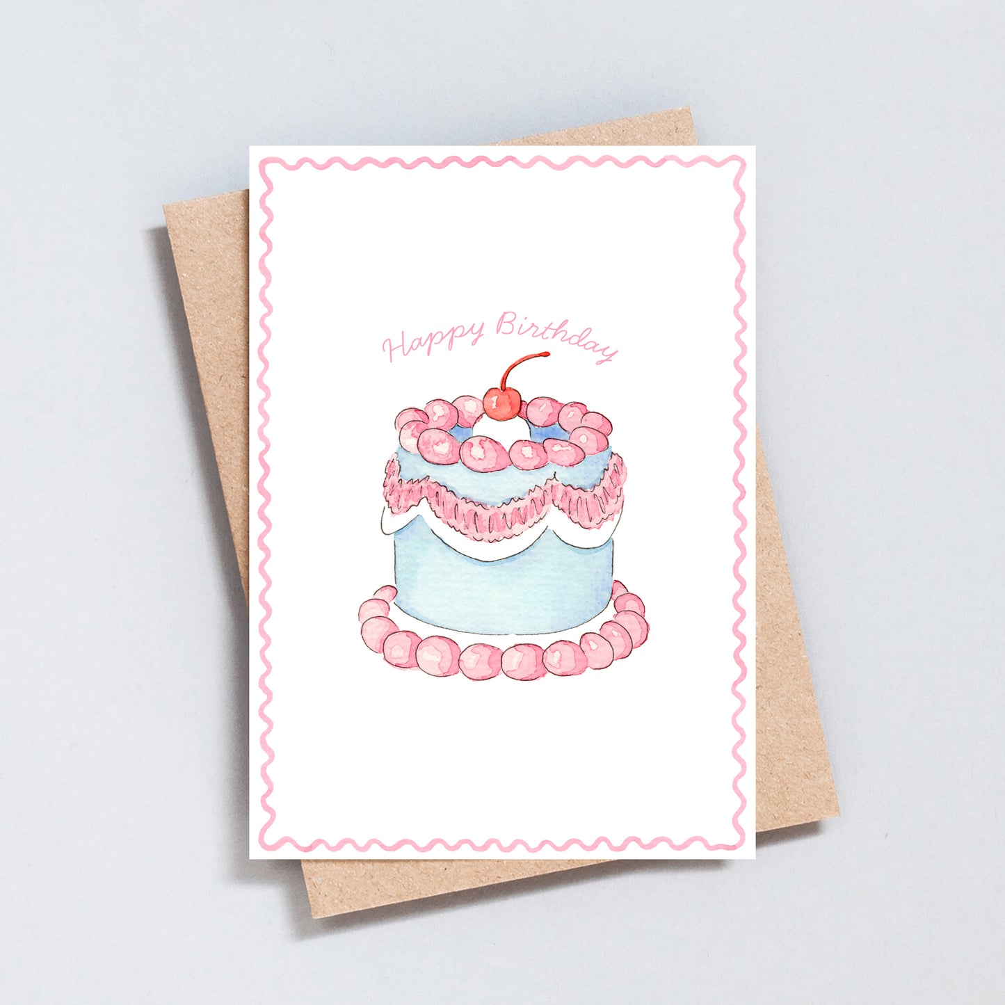 Pastel pink and blue watercolour birthday cake card with cherries and frosting, designed by The Type Club.