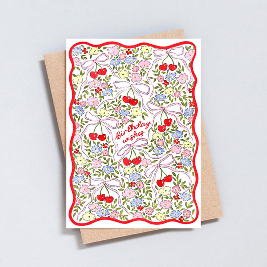 Floral cherry birthday card with pink bows, colourful flowers and red wavy border on textured white background
