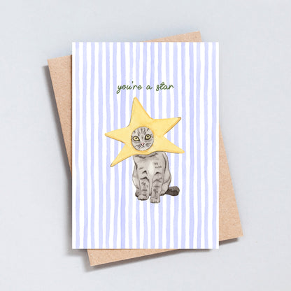 Hand-drawn cat wearing a star costume on a striped background with the text “you’re a star” greeting card.
