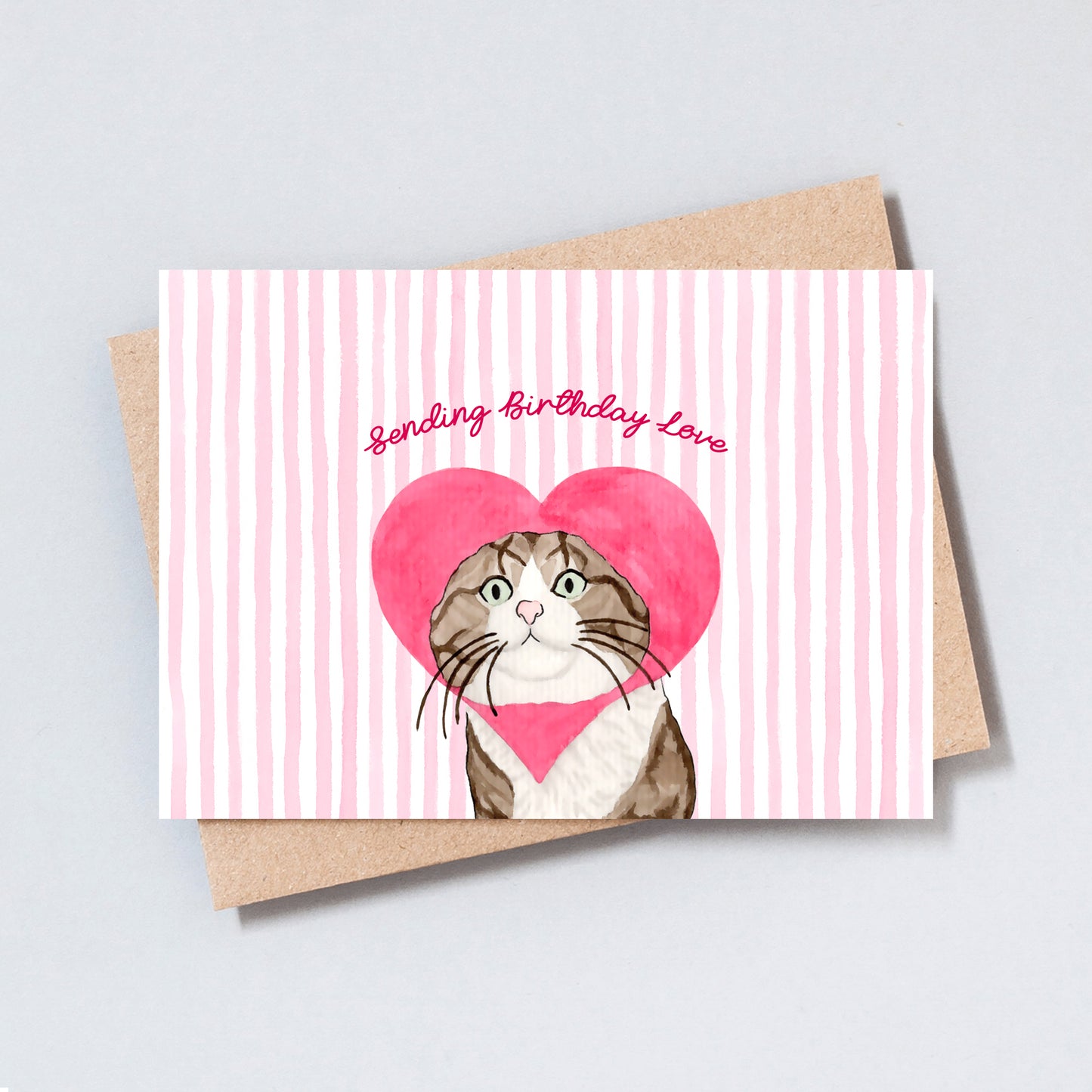 Cute illustrated cat with a pink heart-shaped headpiece and the text “Sending Birthday Love” on a pink striped background.
