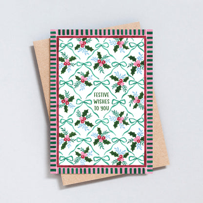Festive Wishes to You Christmas card with hand-painted holly, berries and bows in green, red and blue, surrounded by a pink and green striped border.