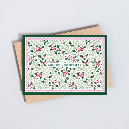 Traditional Merry Christmas card featuring an illustrated holly leaf and berry pattern with decorative scalloped border.