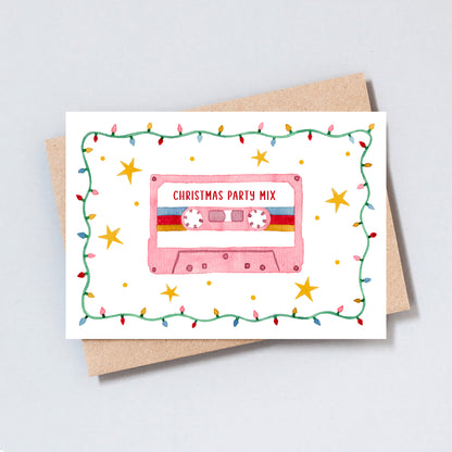 Retro Christmas card featuring a pink cassette tape labeled “Christmas Party Mix,” surrounded by holly and festive lights, illustrated by The Type Club.