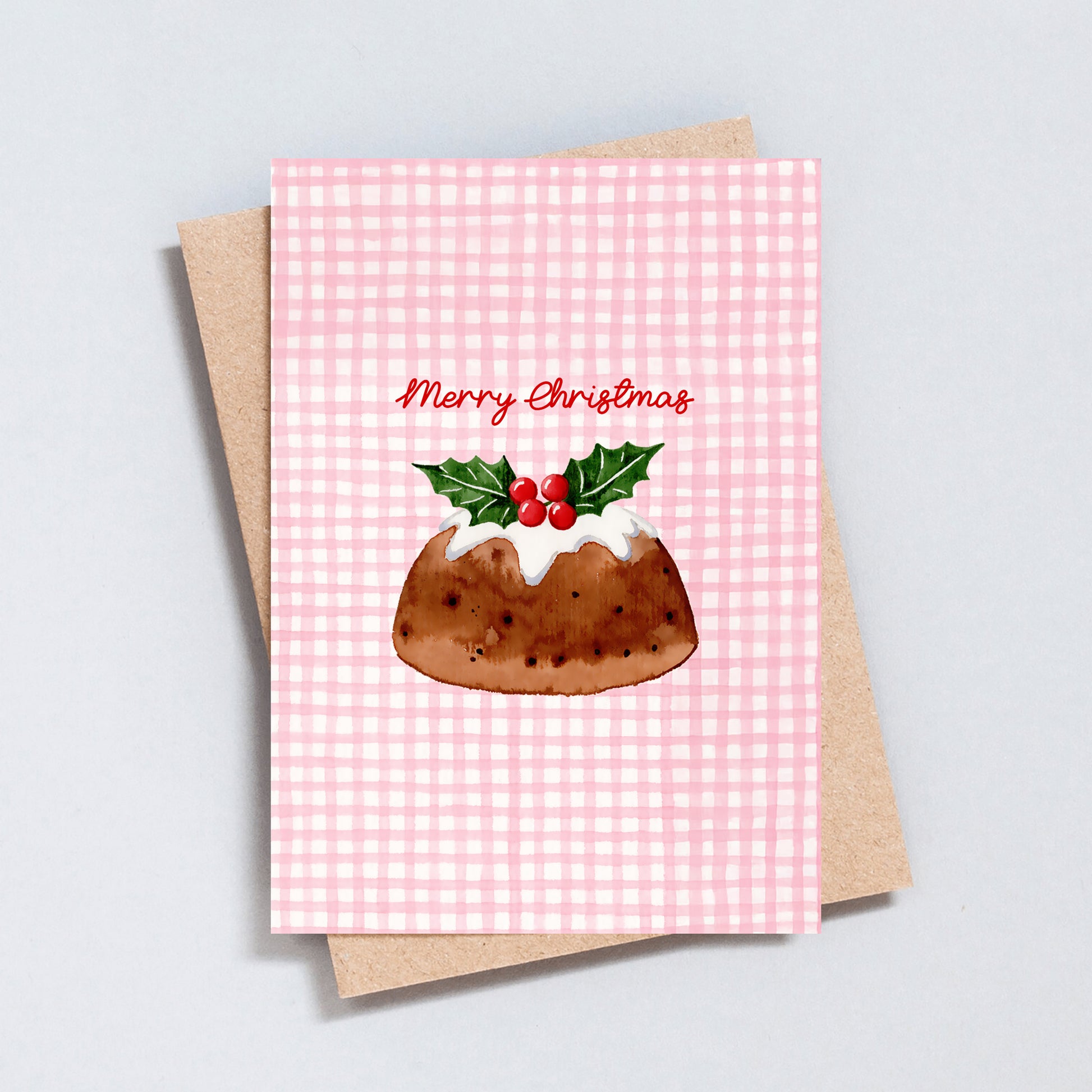 Watercolour Christmas pudding card with holly on top and pink gingham background, reading “Merry Christmas.”