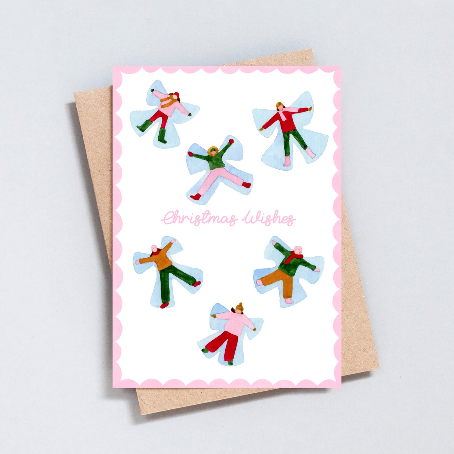 Hand illustrated Christmas card featuring playful snow angels and the words “Christmas Wishes”, printed on hammered 300gsm card with a pink scalloped border.