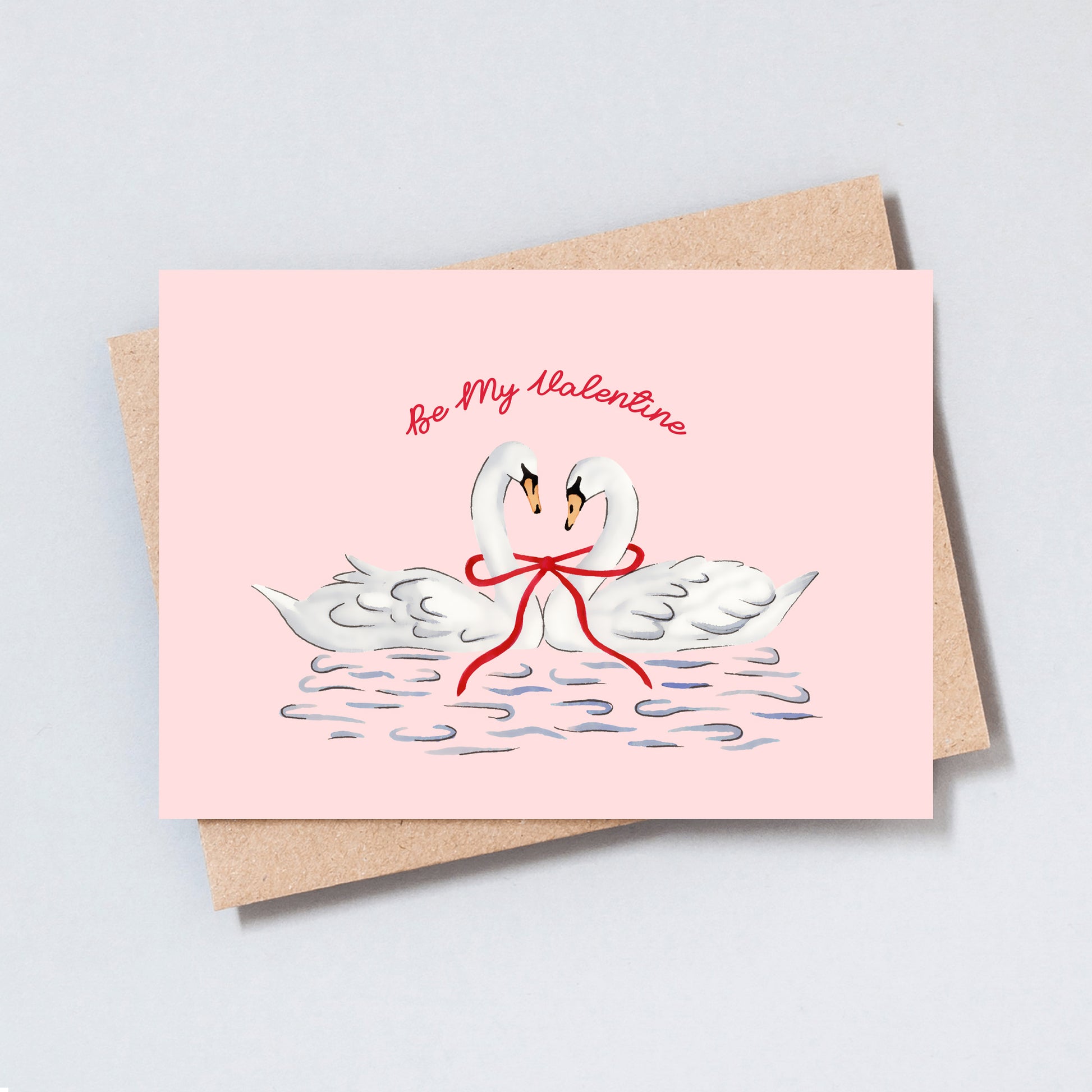 Romantic swan illustration Valentine’s card on a pink background with two swans tied together by a red ribbon.