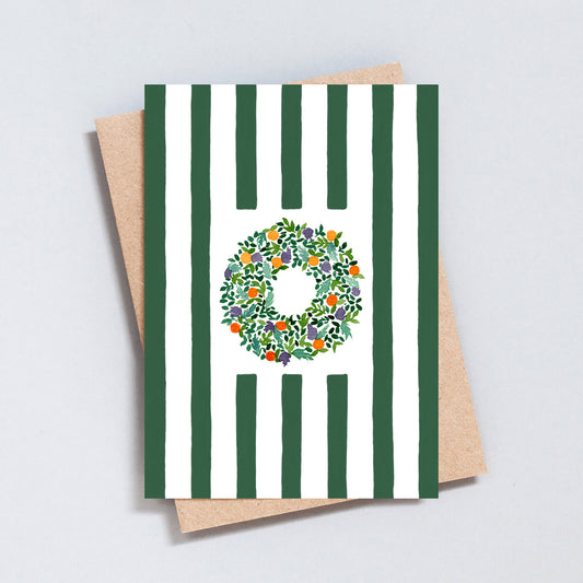 Hand illustrated Christmas card featuring a festive wreath on green and white stripes, printed on hammered 300gsm card.