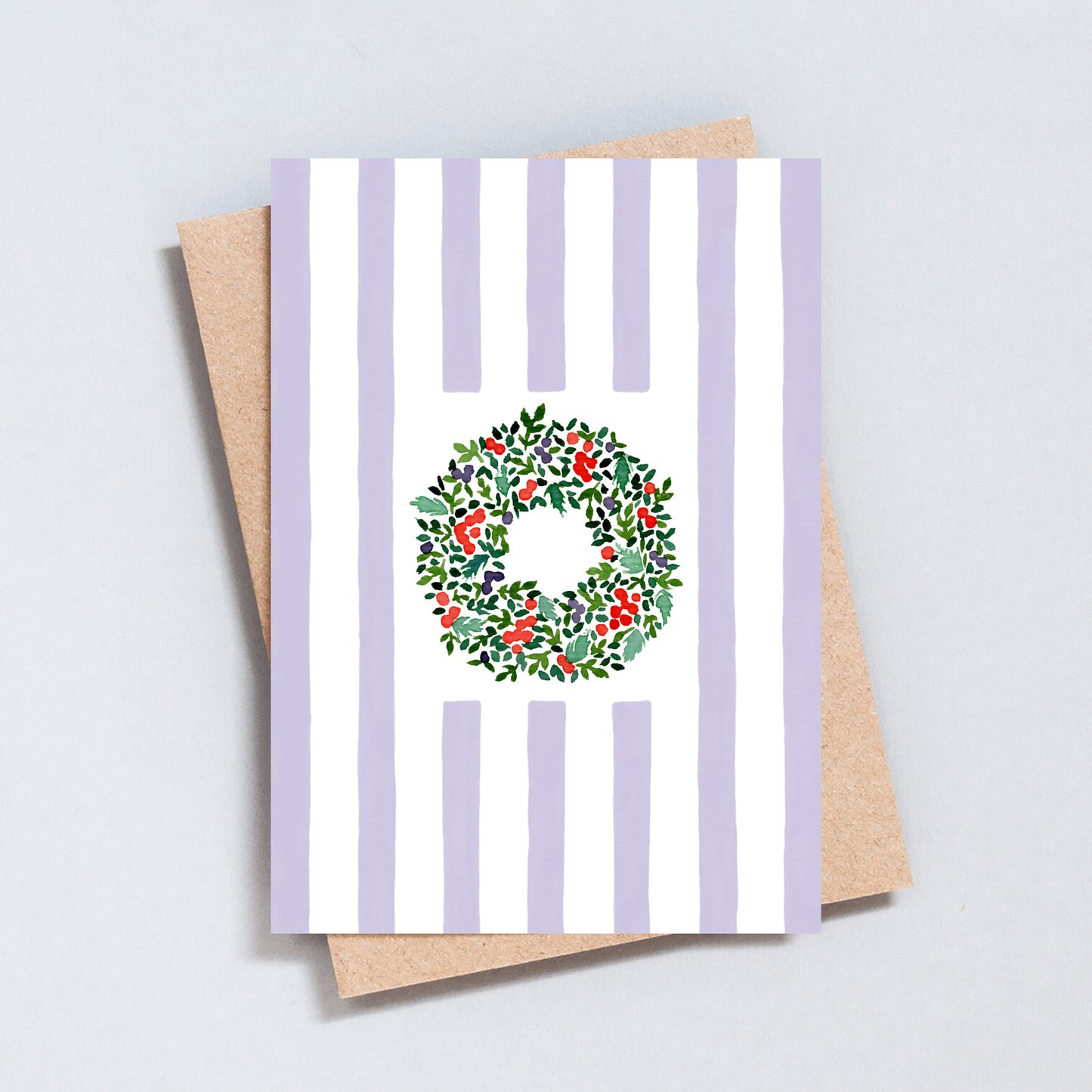 Hand illustrated Christmas card featuring a festive wreath on green and white stripes, printed on hammered 300gsm card.