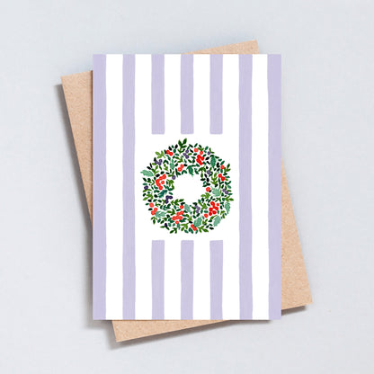Hand illustrated Christmas card featuring a festive wreath on green and white stripes, printed on hammered 300gsm card.