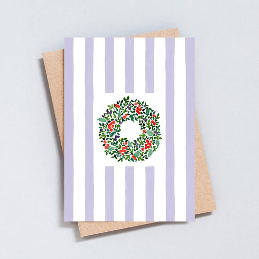Hand illustrated Christmas card featuring a festive wreath on green and white stripes, printed on hammered 300gsm card.