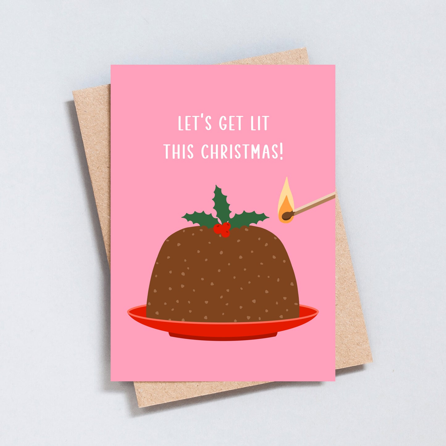 Pink Christmas card with illustrated pudding and match featuring the phrase “Let’s Get Lit This Christmas”